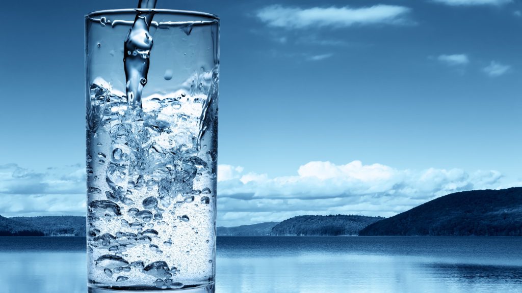 mineral-water-in-a-glass-wonderful-lake-in-the-background-2560×1440